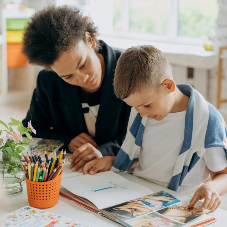 Livres et ressources pédagogiques : une enseignante aide un enfant à lire