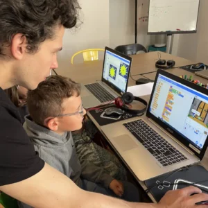 Animateur aidant un enfant sur Scratch