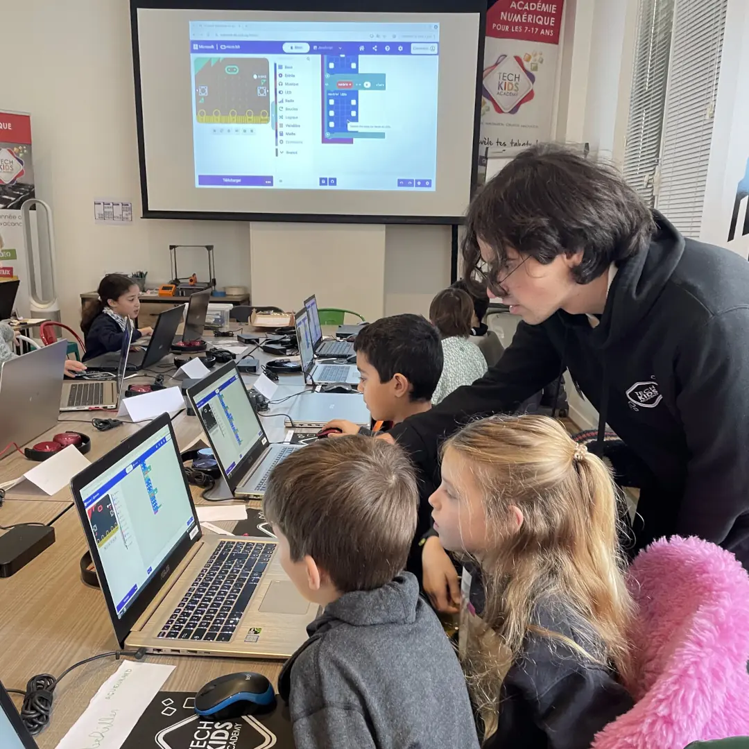 Animateur expliquant aux enfants comment programmer la carte Micro:bit